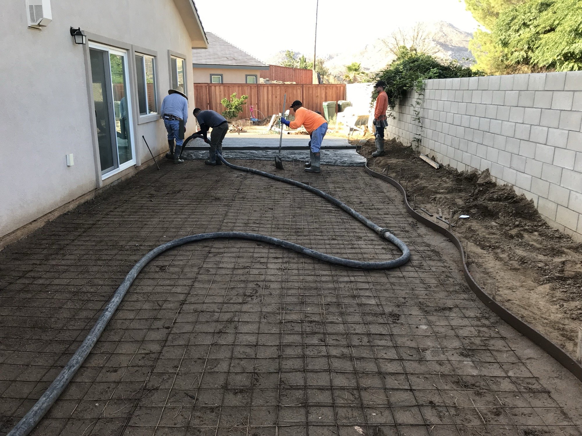 Crew pouring concrete through a pump hose