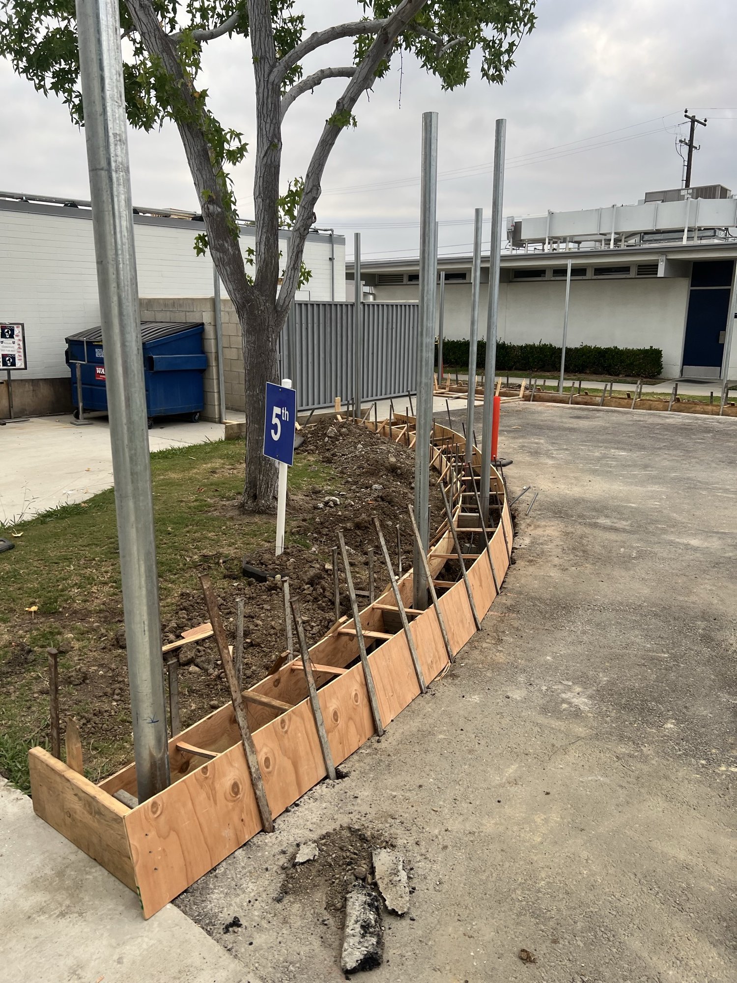 Formed curb pour with embedded steel posts